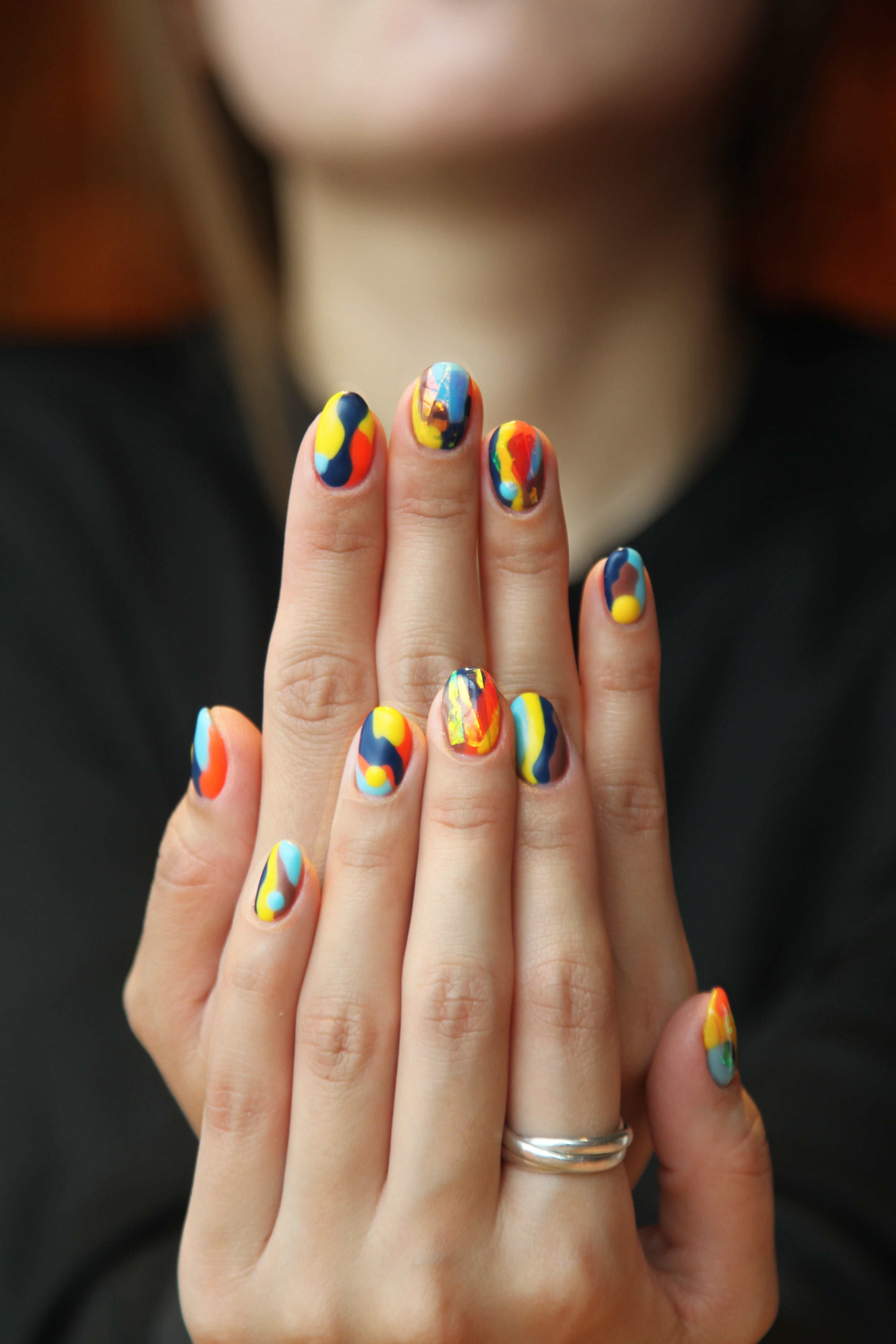 A nail technician working carefully on a model’s hand